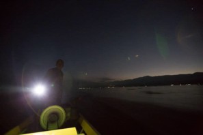 A man drives a boat late at night on Inle lake in Myanmar