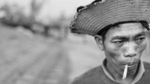 blacm and white portrait of a Vietnamese fisherman smoking a cigarette