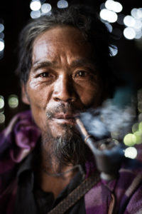 Chin man smoking a pipe