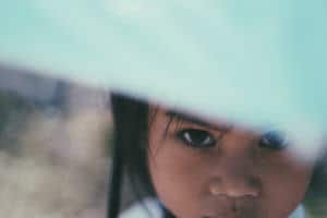 portrait of a young Lao girl hiding