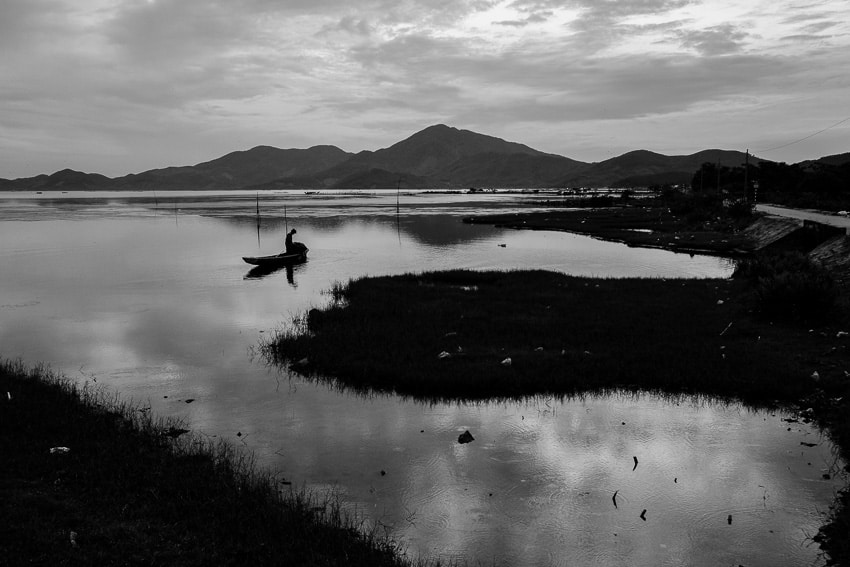 A fisherman at sunrise on Tam Giang lagoon at sunrise taken during a photography tour with Pics of Asia