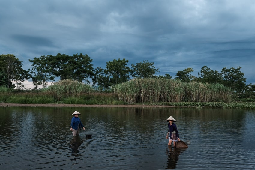 women harvesting clams in the river near Hoi An, taken on a photography workshop with Pics of Asia