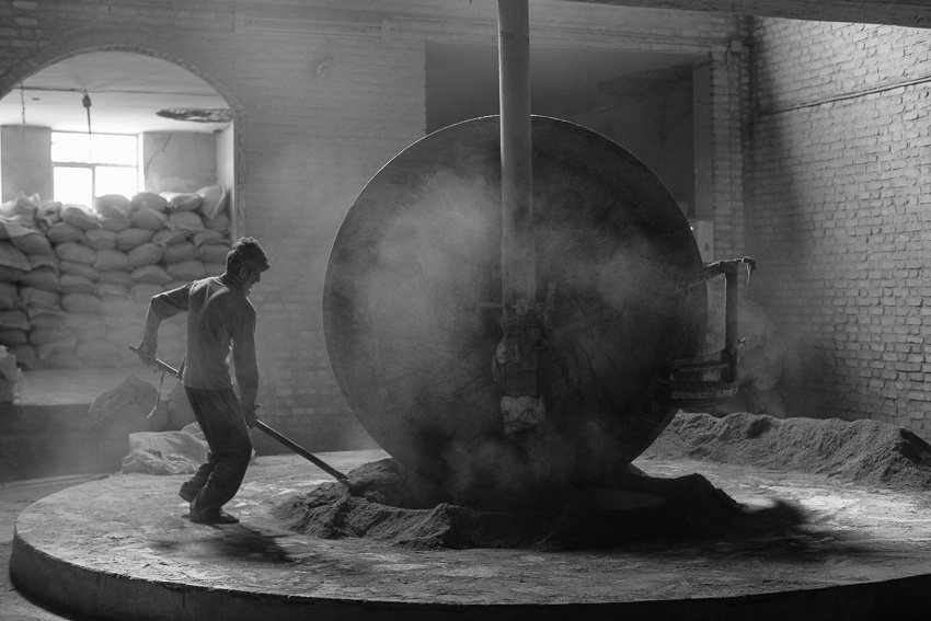 A worker grinding henna in a small factory outside of the city of Yazd in Iran