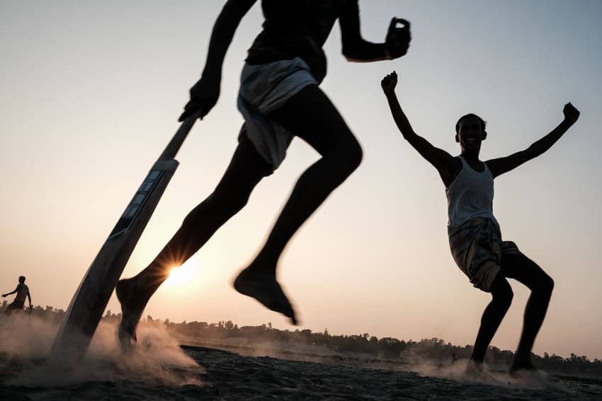 Cricket players cheer for the winning ball, taken at sunset along the Brahmaputra river in Bangladesh during a photography tour by Pics of Asia