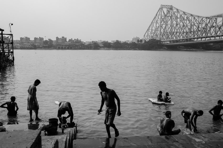 People take a spiritual bath in the water of the Ganges in Kolkata, India