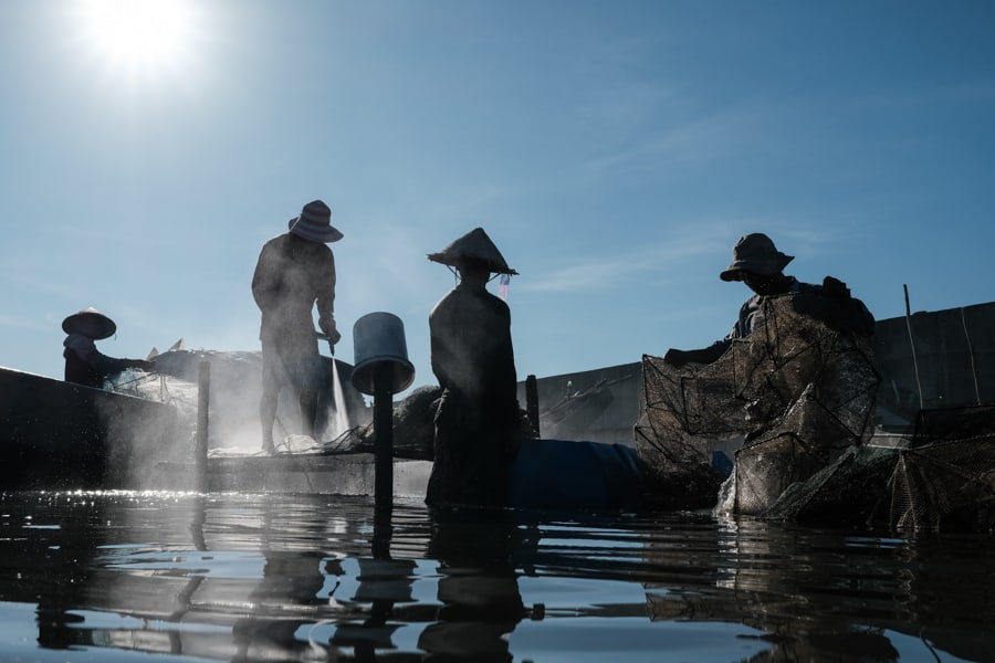 Fishermen cleaning their nets in a lagoon in Hue for a contact sheet for Pics of Asia