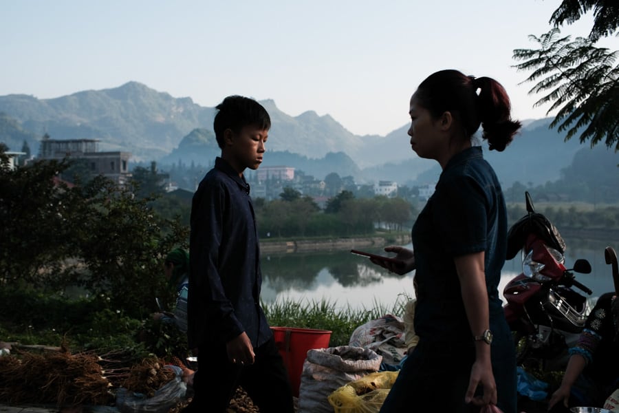 Two people walking through the market in Bac Ha, Vietnam