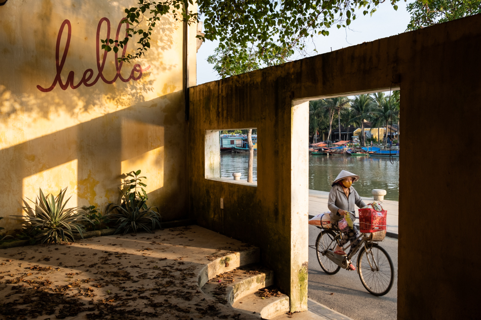 A woman rides a bicycle in the quiet streets of Hoi an old town during the Covid pandemic