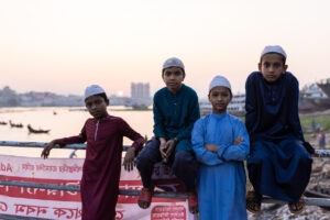 4 boys posing for a photo along the river in Dhaka