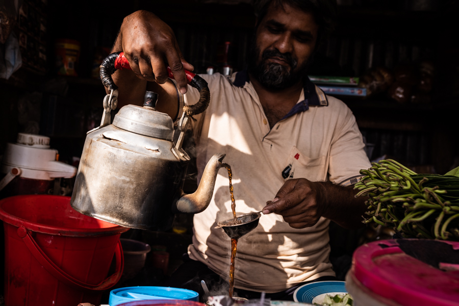 a man pouring tea at a tea stall in Barisal, Bangladesh