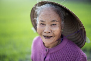 Portrait of a Vietnamese woman in front of green rice fields on a photo tour with Pics of Asia