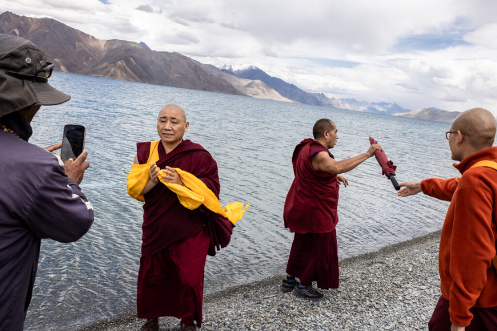 monks take selfies in front of the Pangong lake in Ladakh, India